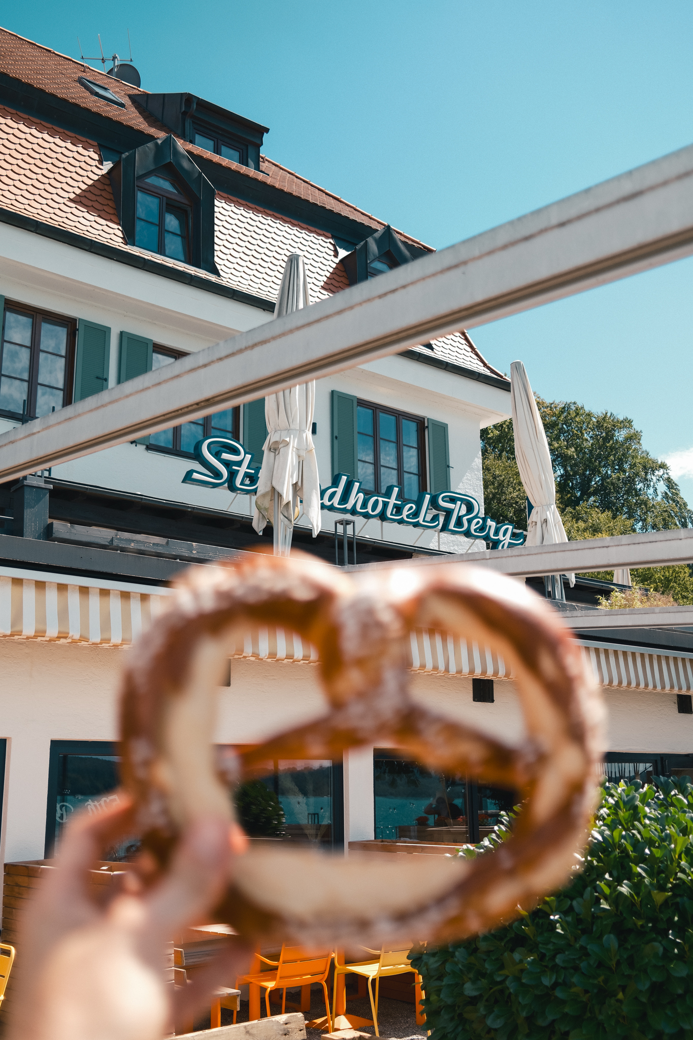 Die Seeterrasse des Strandhotel Berg mit Markisen und Bootssteg am Starnberger See
